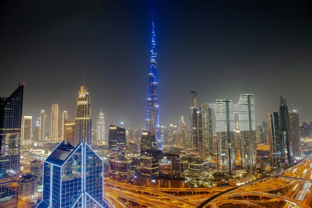 Stunning aerial view of Dubai's skyline with the Burj Khalifa at night, showcasing vibrant city lights.